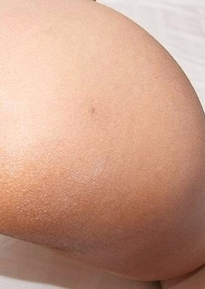 Manaw is dressed in a tight silver top and matching little booty shorts hugging her all natural, curvy body.
